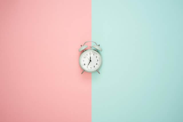 Clock on a half green, half pink background